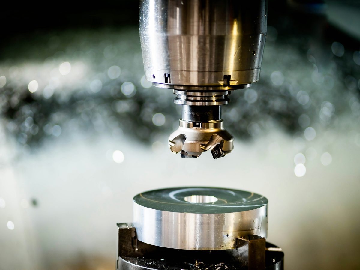 CNC-Fräsmaschine bearbeitet Metallteil mit Kühlmittel