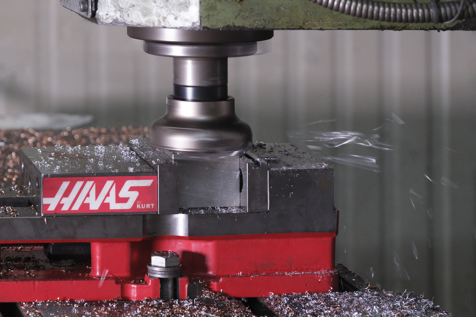 CNC-Fräsmaschine bearbeitet Metallteil mit Kühlmittel